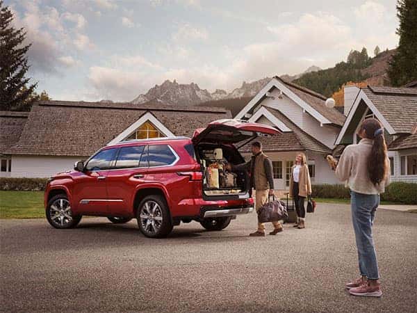 Family in front of house packing a Toyota vehicle with luggage for a vacation.