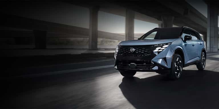 Nissan Rogue Hybrid driving under a highway bridge