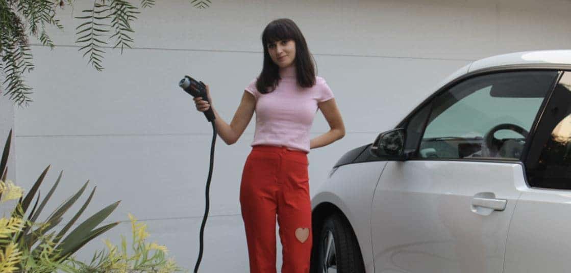 Young woman holding EV charger